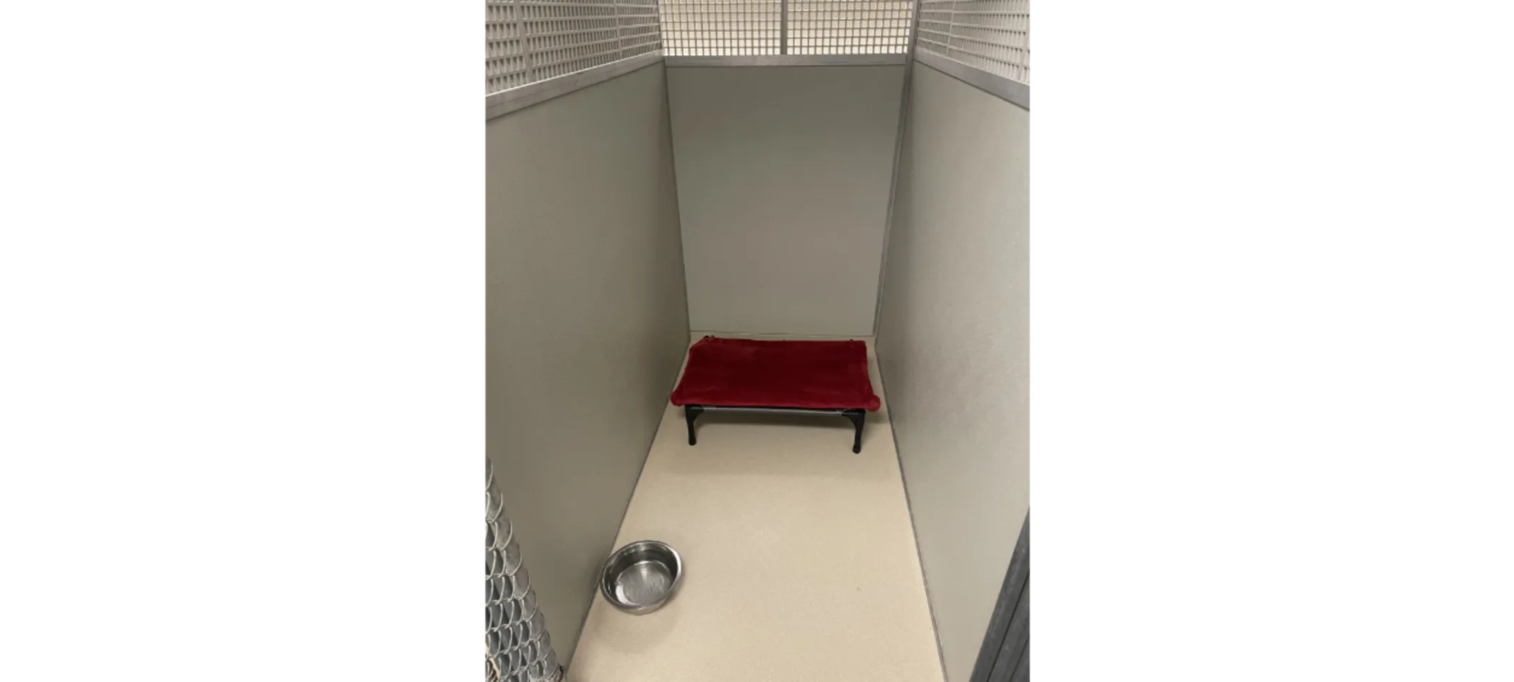 Small dog kennel with red dog bed and bowl